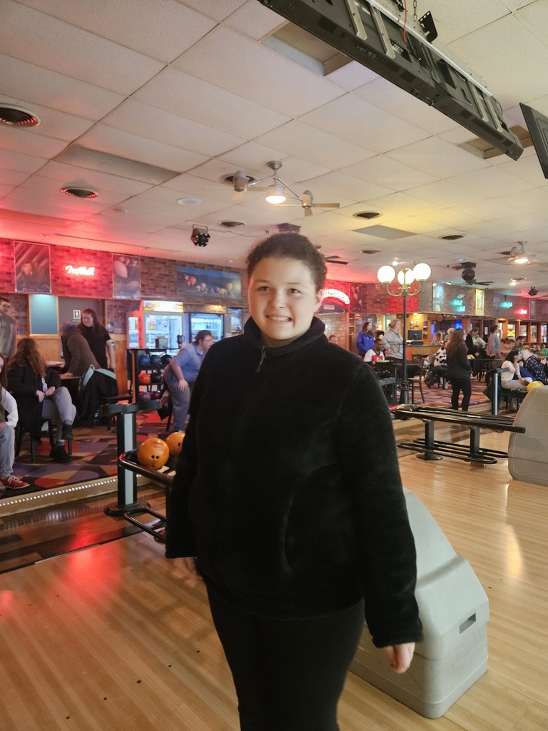 young person in a black fleece jacket is seen standing near the approach area, smiling for the camera