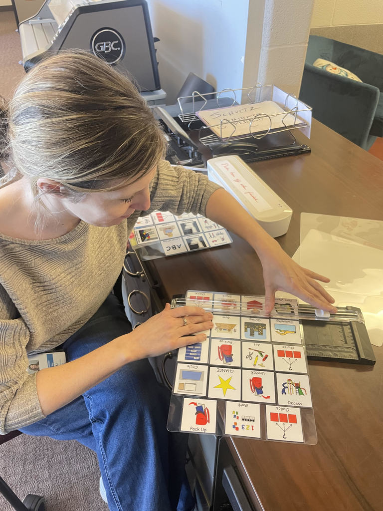 Adult cutting visuals, sitting at a desk