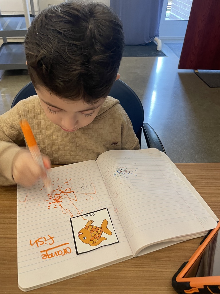 Student is writing in a notebook with a marker.