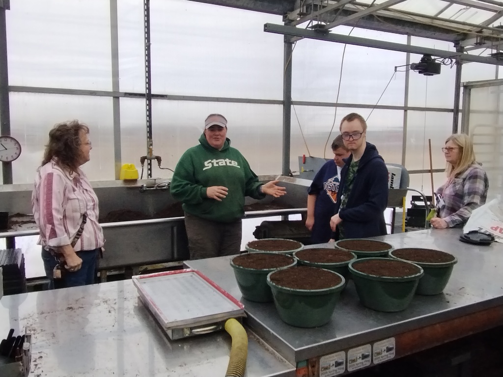 Teachers and young adults learning about jobs in a nursery.