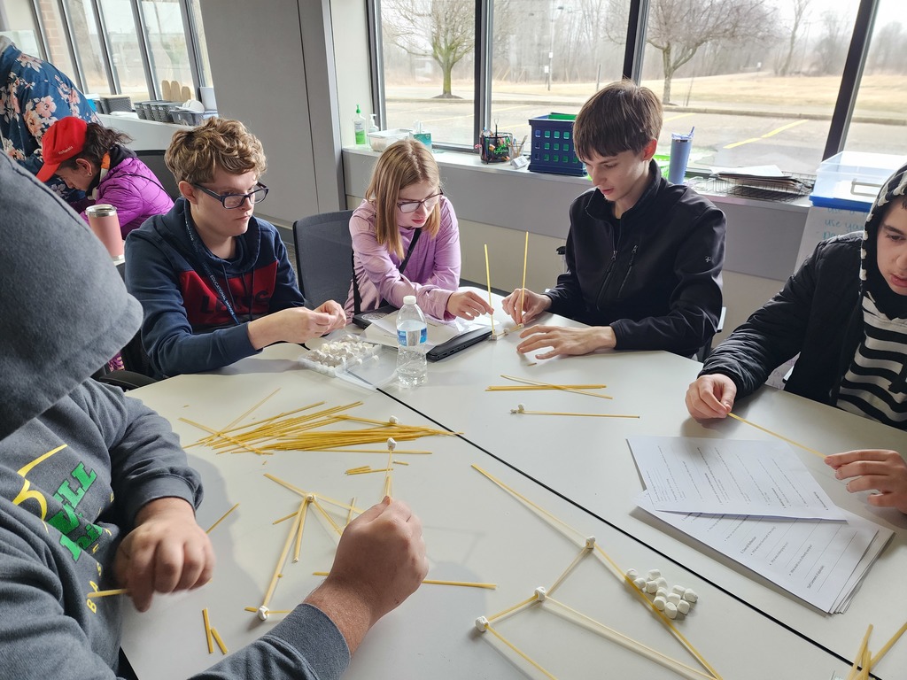 A group of young adult learners building with spaghetti and marshmellos.