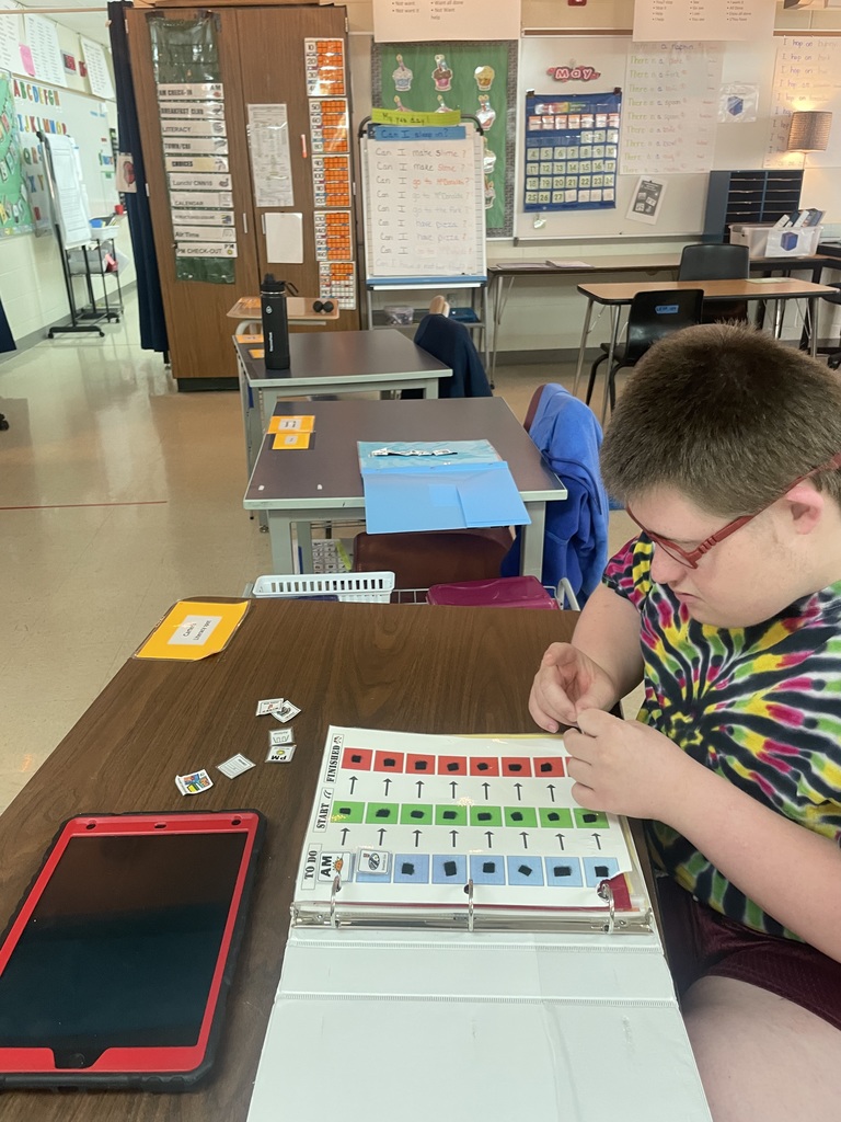 Student sitting at a desk setting up his own visual schedule. 