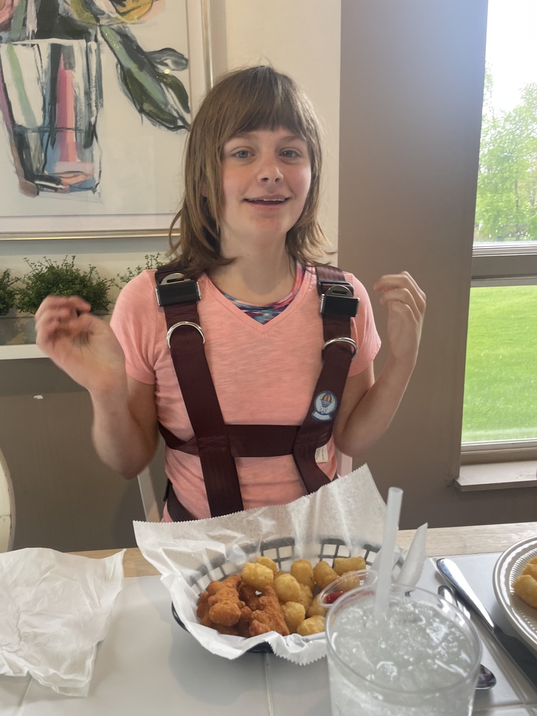 Student sitting at table eating a basket for chicken fingers.
