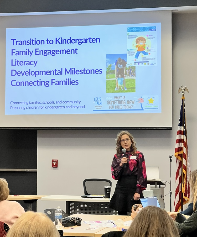 Woman holding microphone gives a speech to a room full of people 