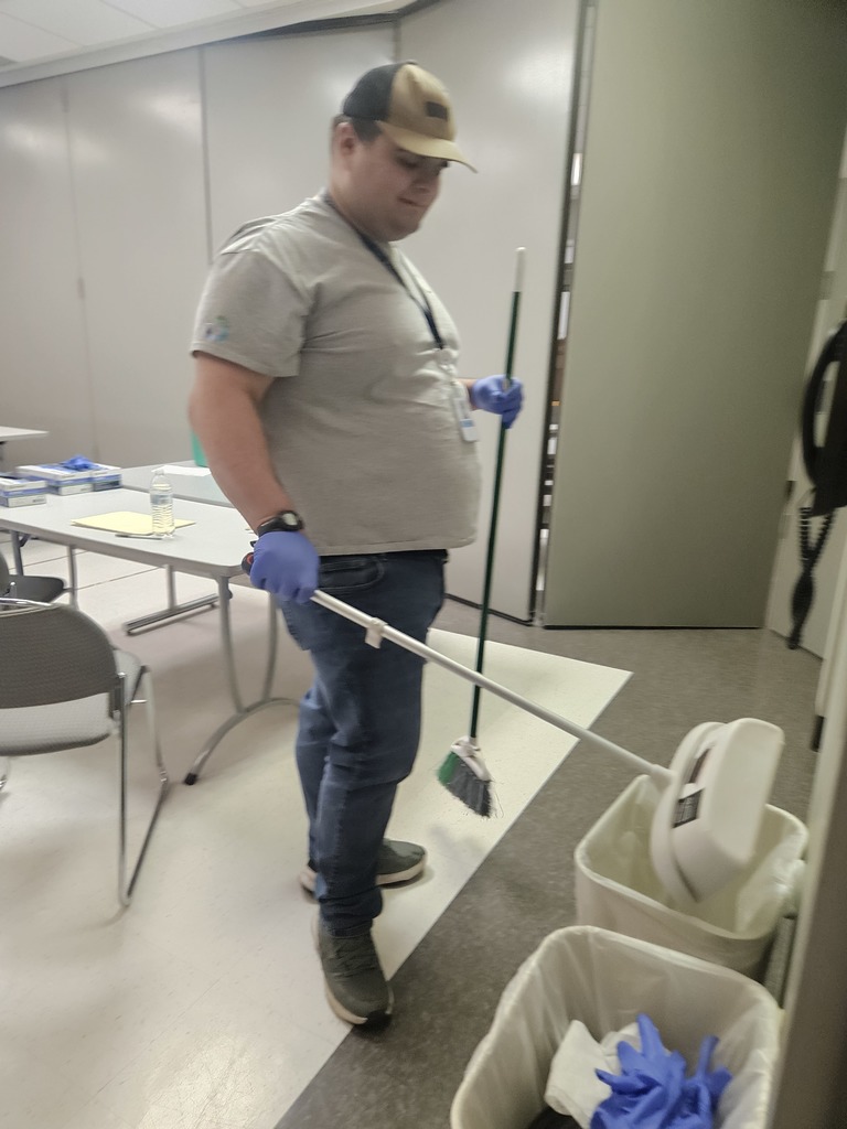 man emptying dustpan into the trash 