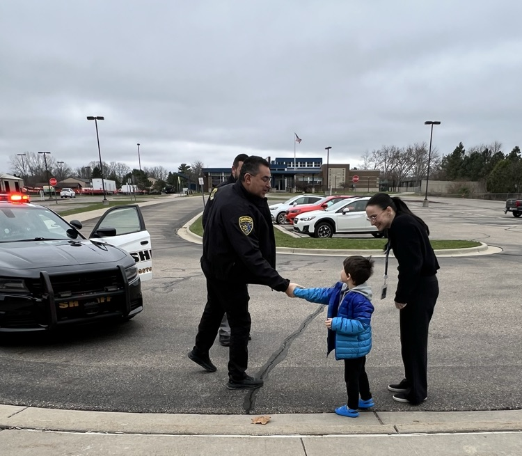 Young boy shakes the hand of officer 