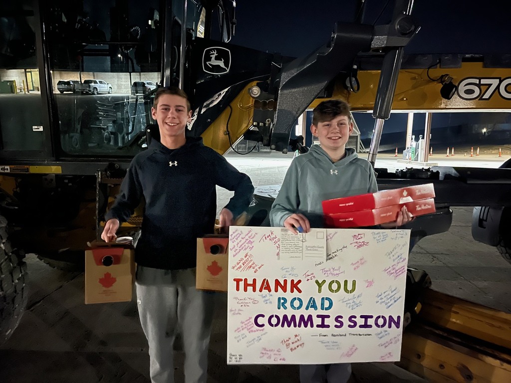 Two kids standing outside with a sign that says "Thank you road commission"