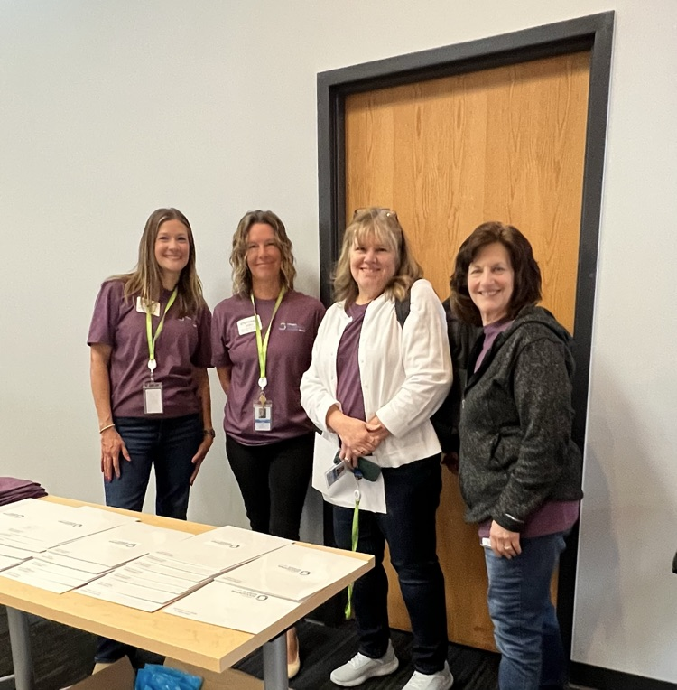 Four women standing behind a table.