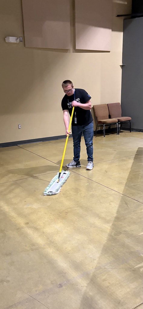 Man sweeping in an auditorium.