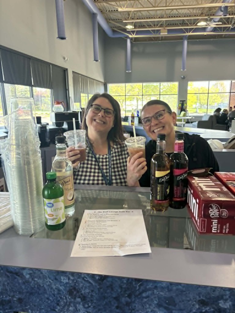 Smiling teacher and job coach each holding a cup of dirty soda.