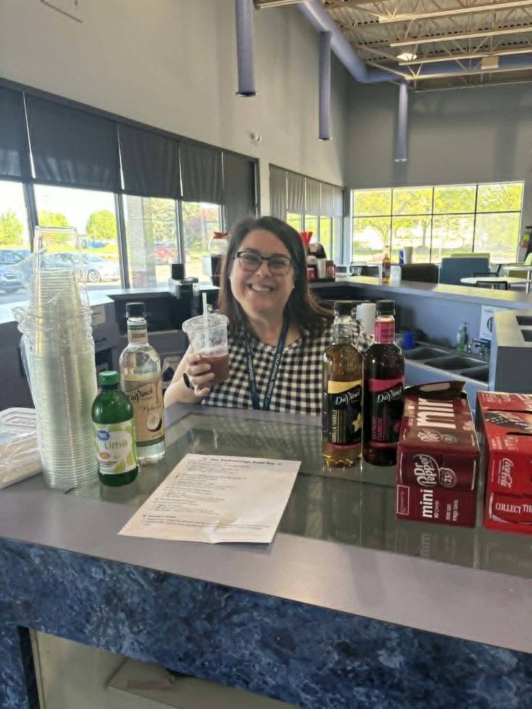 Job coach smiling while holding a cup of dirty soda