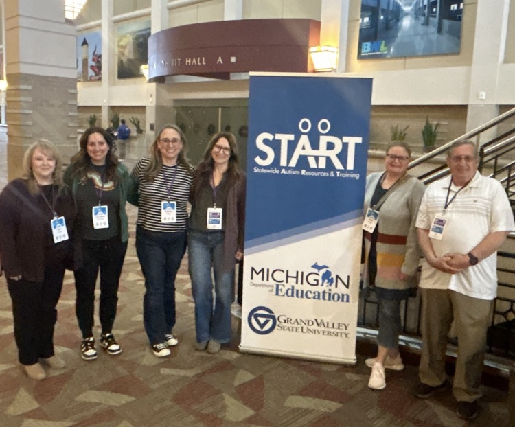 A group of five female woman and one male posing in front of a banner sign that says "START"