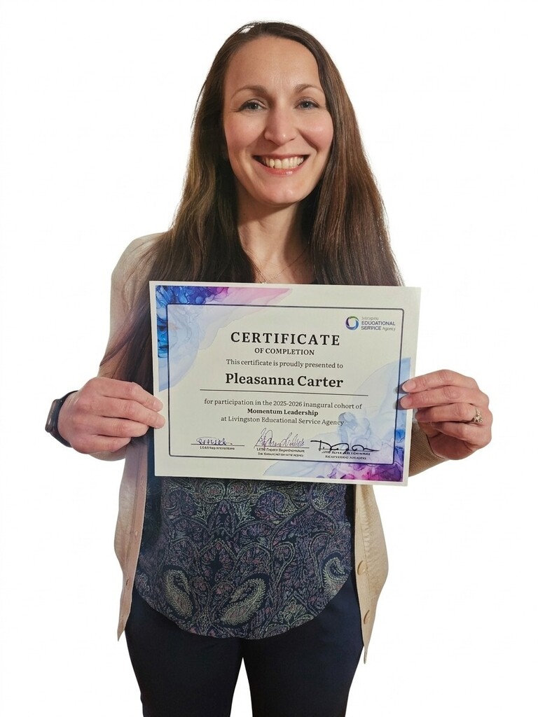 A woman holding a certificate of completion, addressed to "Pleasanna Carter". She is wearing a patterned navy top and a light beige cardigan.