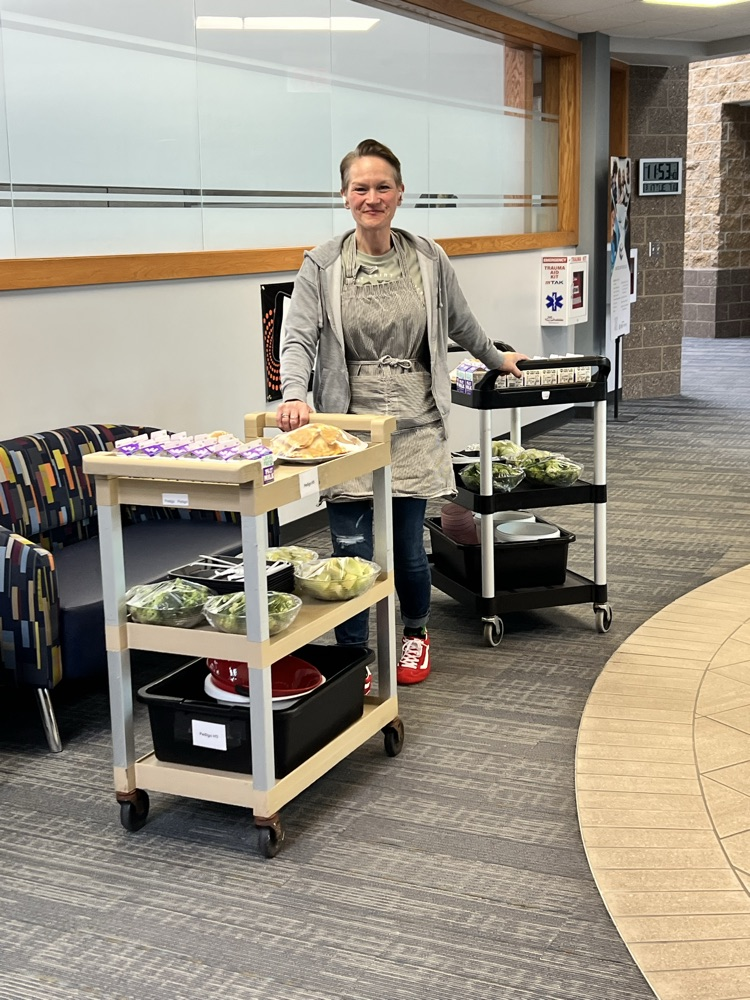 Woman pushing and pulling carts with food for lunch.