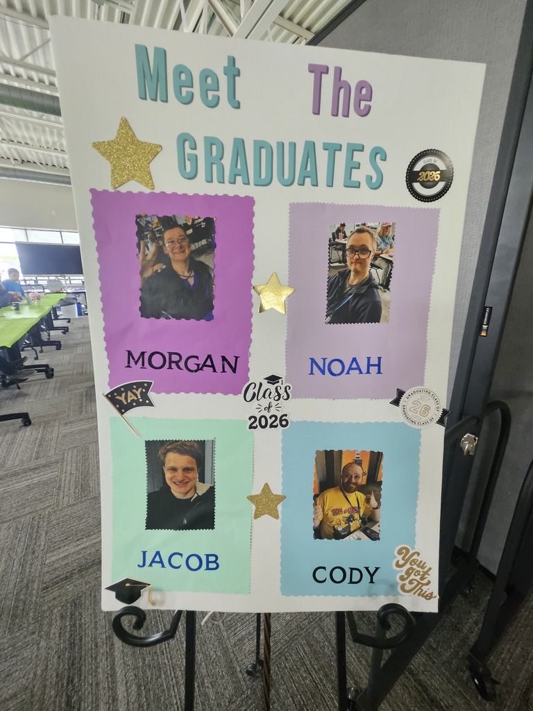 A poster on an easel reads "Meet The GRADUATES Class of 2026." The poster features photos and names of four individuals arranged in a grid: Morgan (top left), Noah (top right), Jacob (bottom left), and Cody (bottom right), decorated with gold stars and graduation stickers.