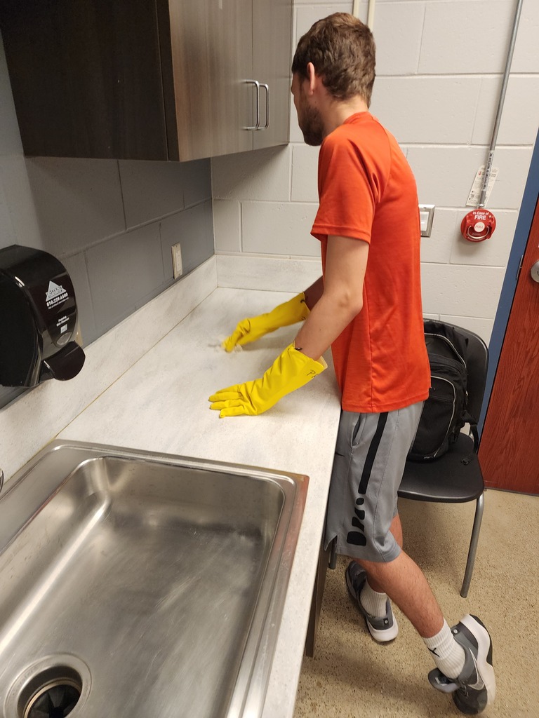 A male adult learner is cleaning the counter.