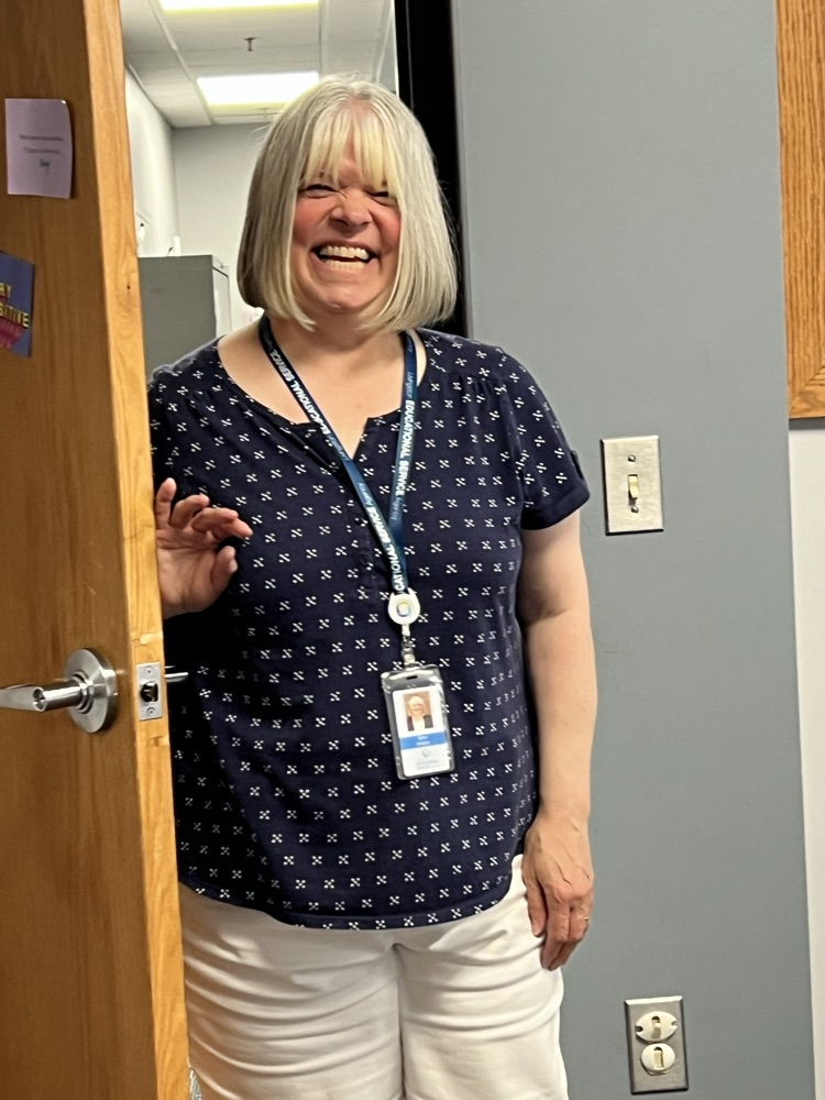 A very happy woman walking through a doorway.