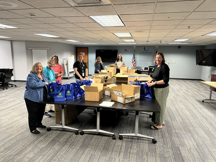 Group of women standing around a table packing bags