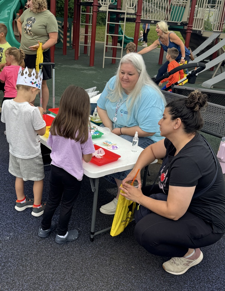 Woman sitting at a table with two children and their mother.
