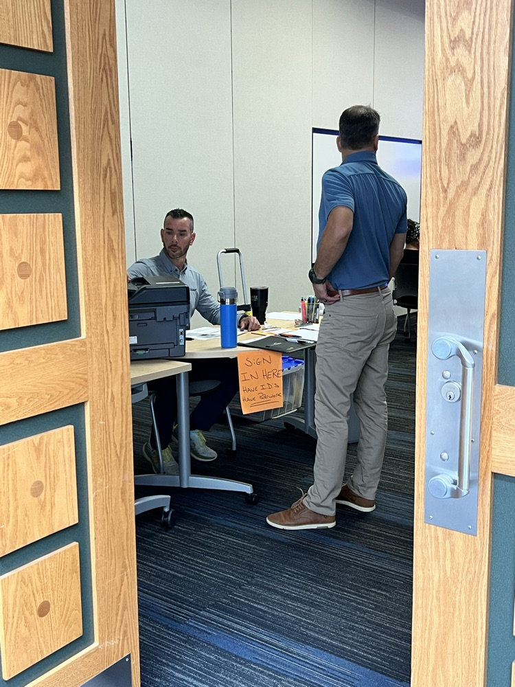 Man checking out paperwork for a new substitute teacher.