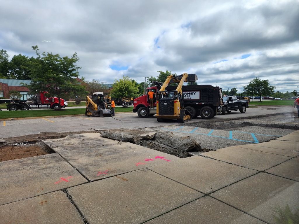 Construction trucks working on a parking lot project.