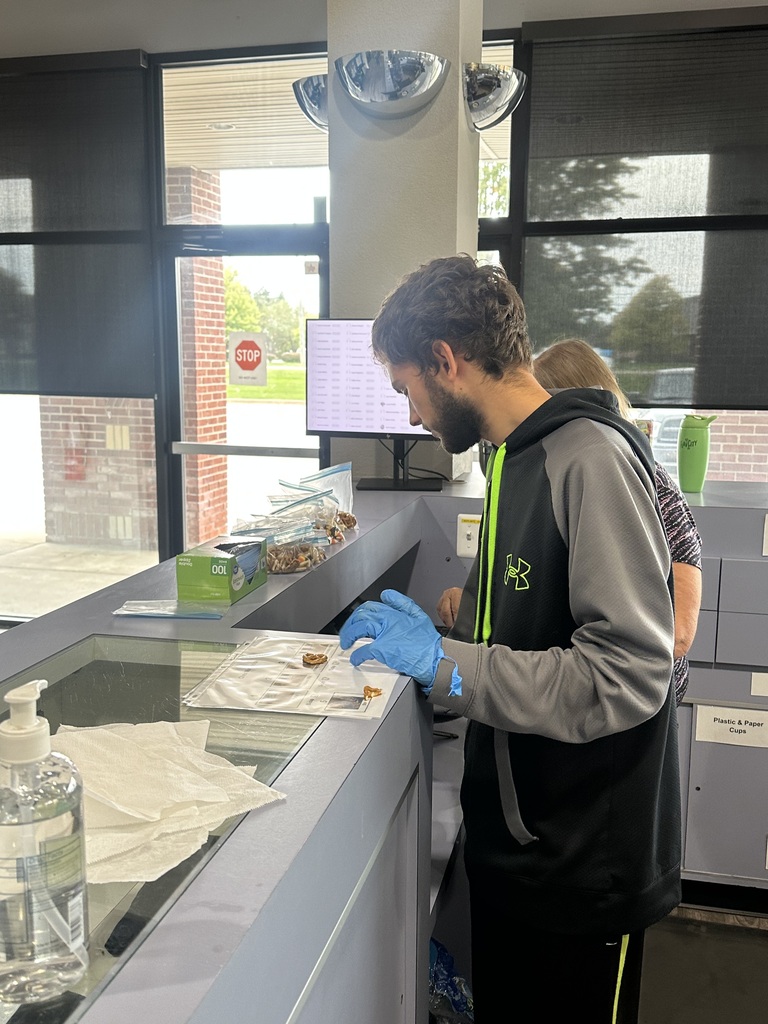 PREP student wearing blue disposable gloves completing a task list at a counter.