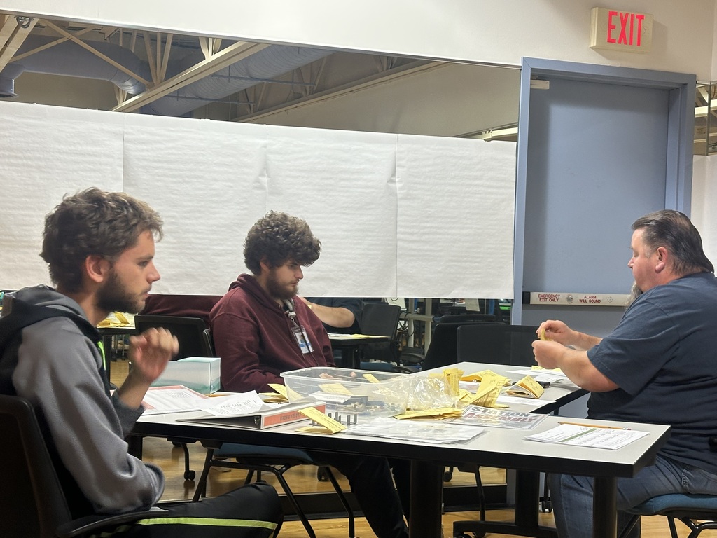 PREP students and a Job Coach completing assembly tasks at a table.