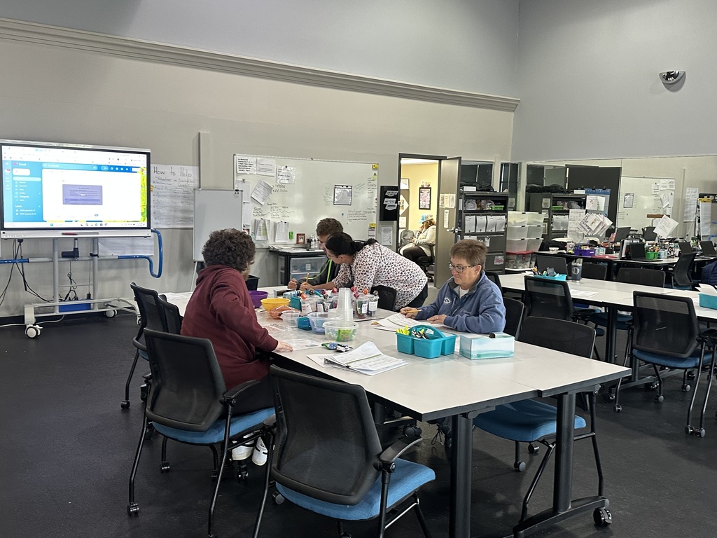 Instructors working with PREP students at a classroom table.