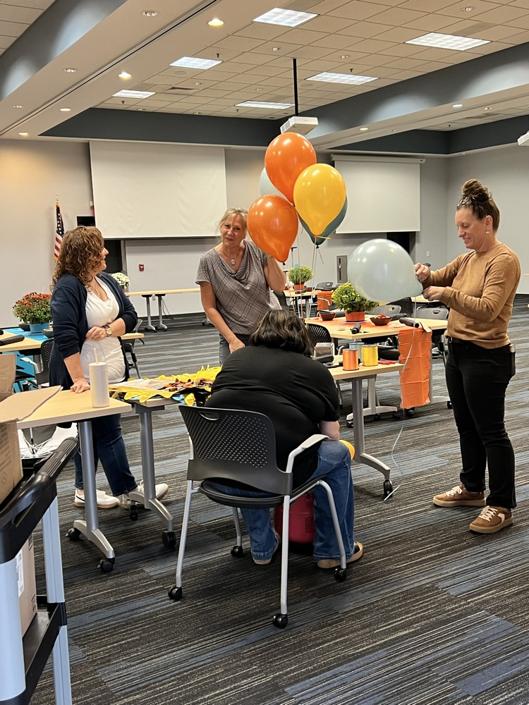 Four women work to blow up balloons for their upcoming CTE teacher in service