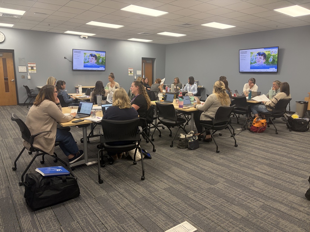  A group of GSRP teachers participate in a professional training session, seated around tables with laptops and training materials as they learn about a new ongoing assessment tool they will pilot this year.