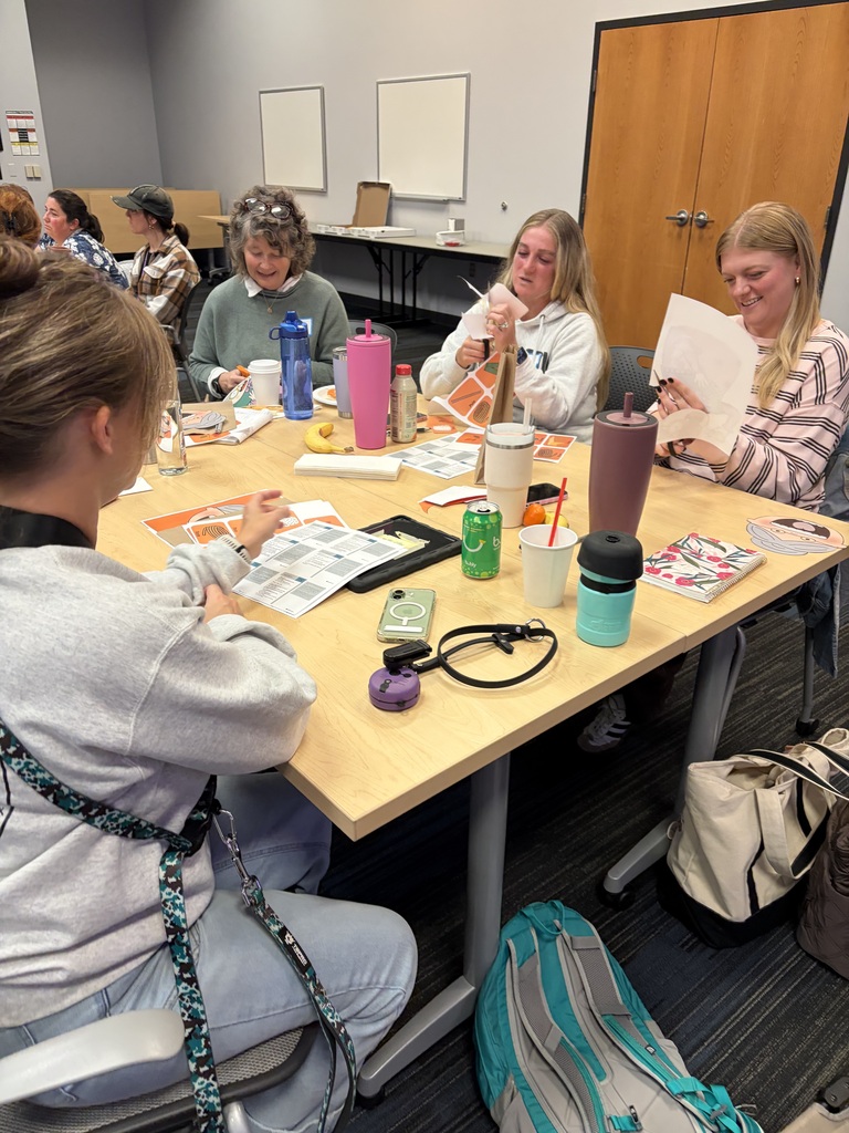 Preschool teachers collaborate during a professional learning day, creating colorful puppets and hands-on materials to bring back to their classrooms and support learning through play.