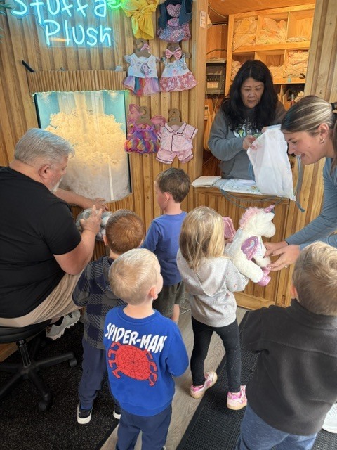 GSRP students gather inside The Bear Factory trailer as staff help them create and stuff their own plush animals.