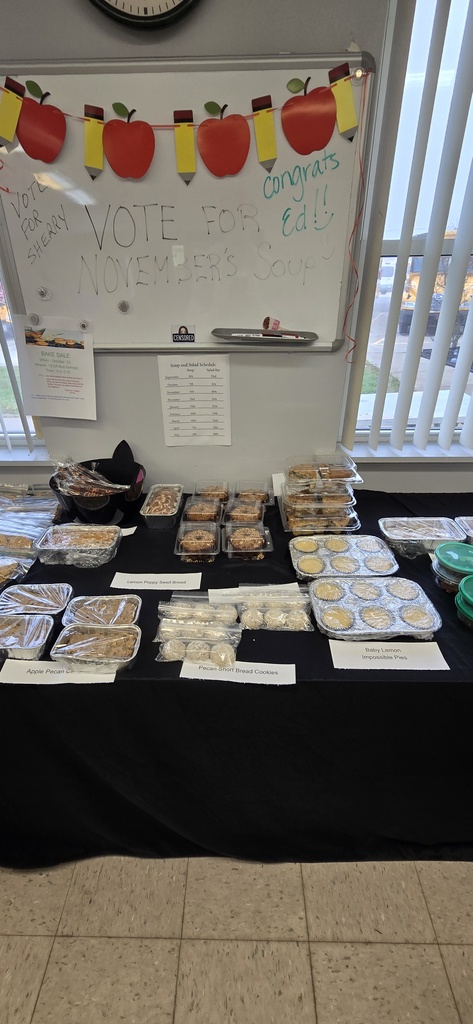 Baked goods individually packaged on a covered table for a bake sale. 