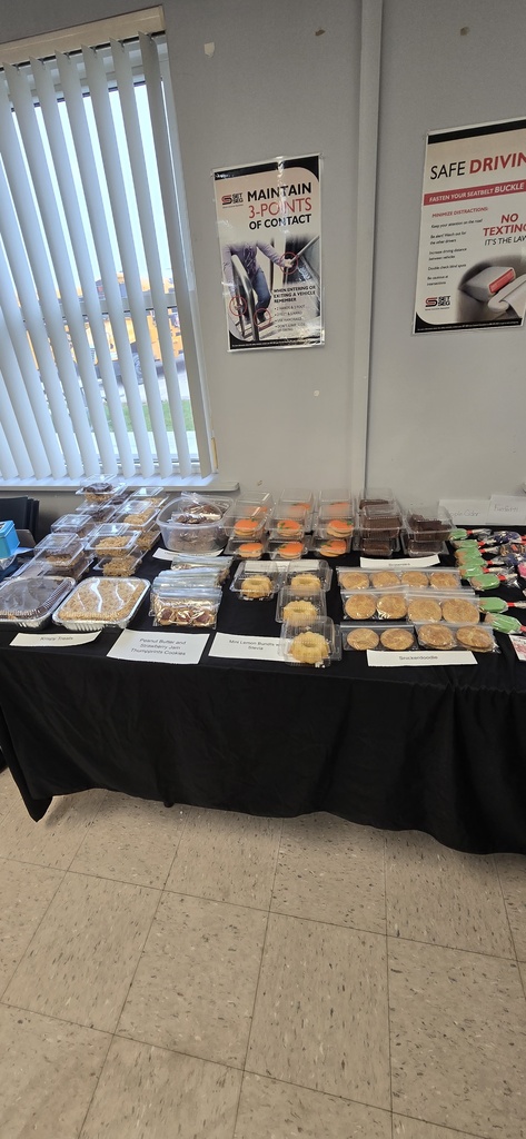Baked goods individually packaged on a covered table for a bake sale. 