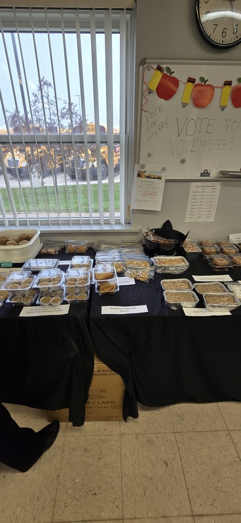 Baked goods individually packaged on a covered table for a bake sale. 