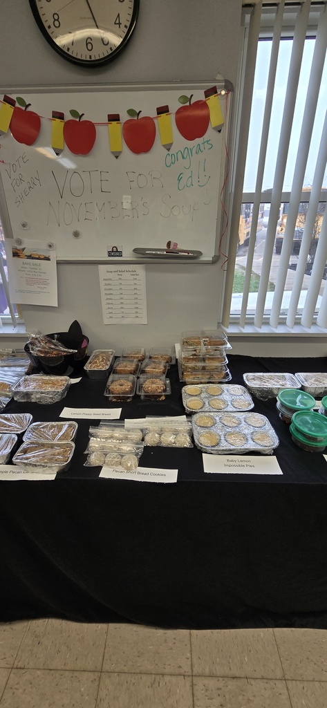 Baked goods individually packaged on a covered table for a bake sale. 
