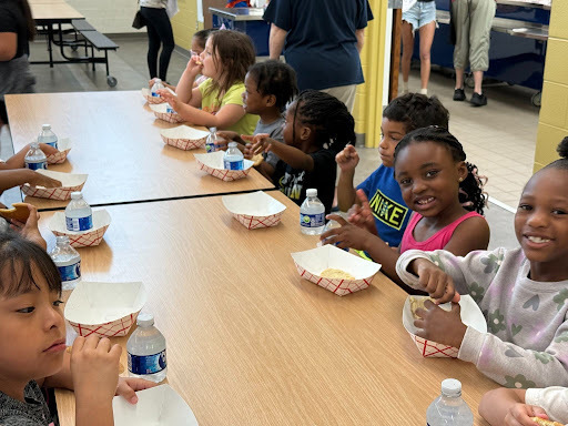 Young students seated at a table where they have a snack and water
