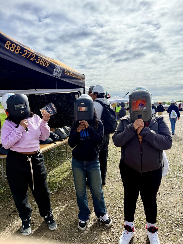 students standing wearing welders masks