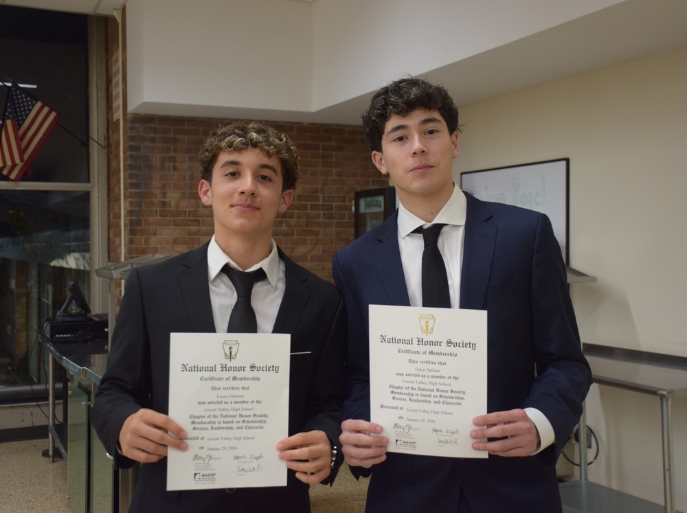 Two new NHS inductees show their diploma.