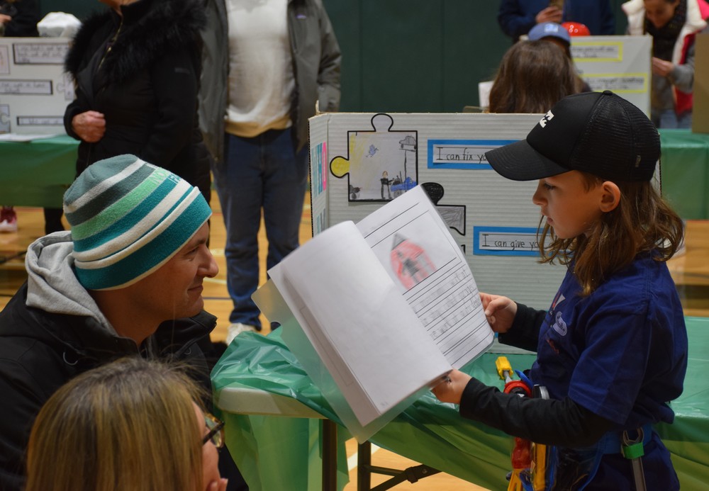 A Bayville Primary second grader explains the plumbing profession to a guest.