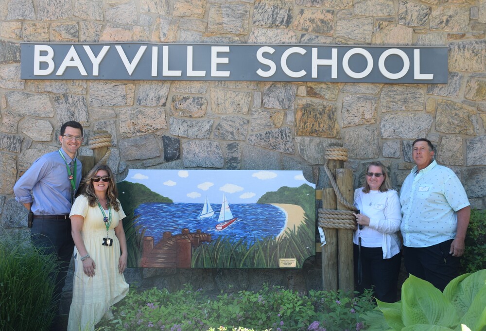 Bayville Primary School principal Ross Cohen and art teacher Jessica Cestaro celebrate the unveiling of the new mural in memory of former student Matthew Fetzer with his parents Ann and William Fetzer.