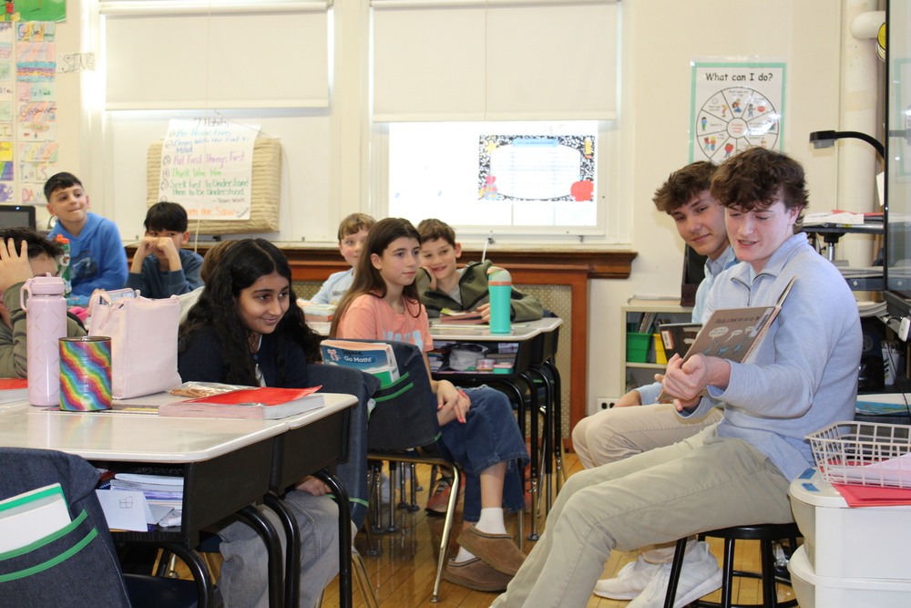 A class at Locust Valley Intermediate School listened on as Locust Valley High School students Ryan Sullivan and Nick Ardeljan read “Don’t Let the Pigeon Drive the Bus!” by Mo Willems.