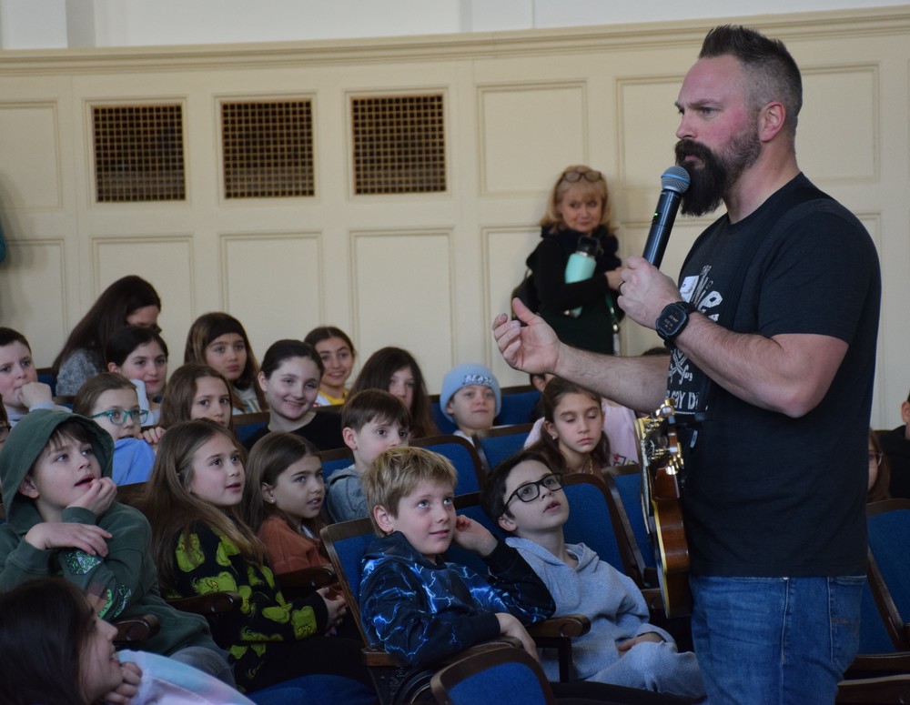 Bayville Intermediate School students listen to Jared Campbell talk about spreading positivitiy.