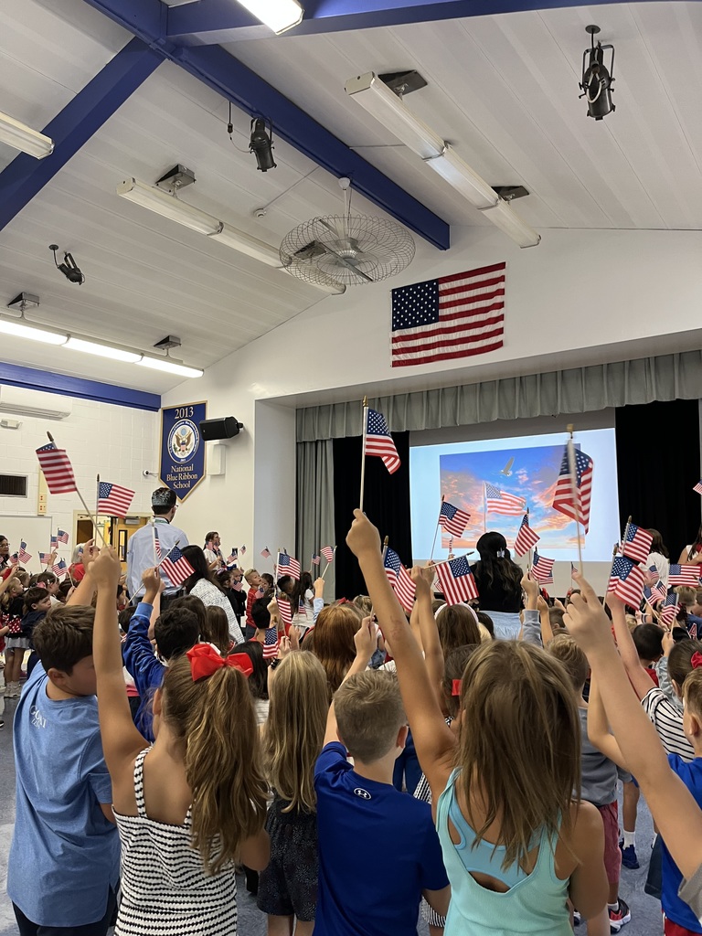 Students at Bayville Primary School students waive their flags during the ceremony.