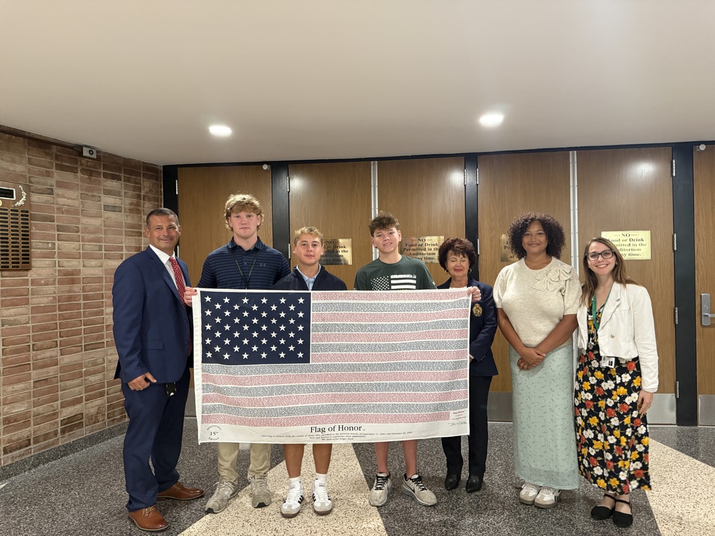Locust Valley High School students Liam Roberts, Kai Charon, James Fox and Samiyah Michalski and staff members Joe Enea, Rita Conforti-Spence and Brianna Blake displayed a flag with the names of all who lost their lives on September 11, 2001.