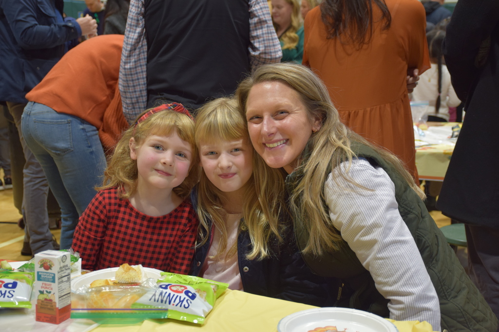 An AMP student welcomes her family to the Thanksgiving Feast.