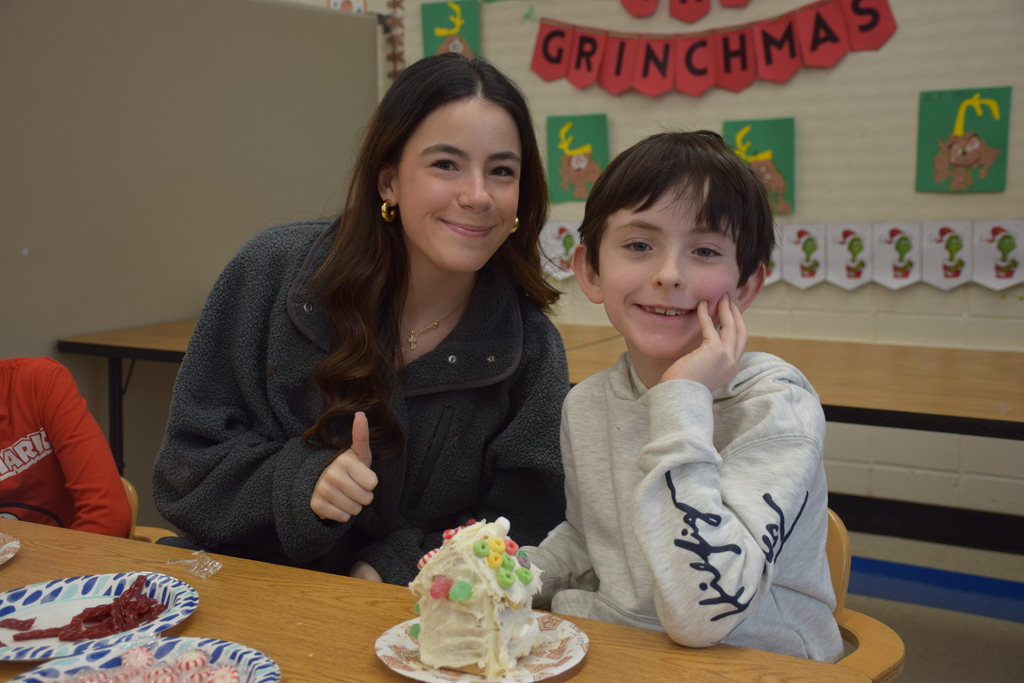 A BP student works with a member of the HS Interact Club on his gingerbread house design.