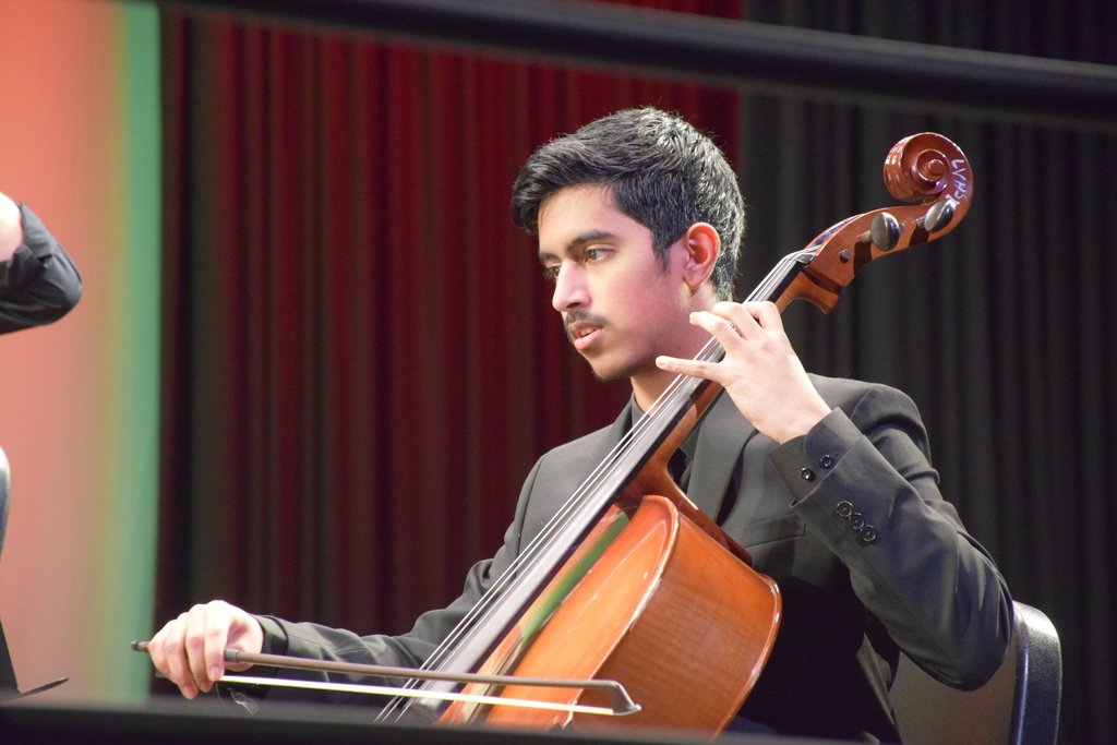 A high school celloist performs in the string orchestra.