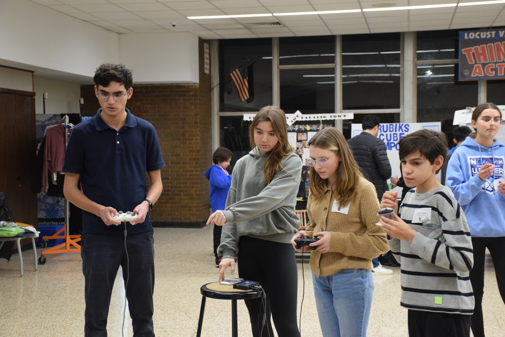 Members of the high school's robotics team "Kuiper" show middle school students how their contraption works.
