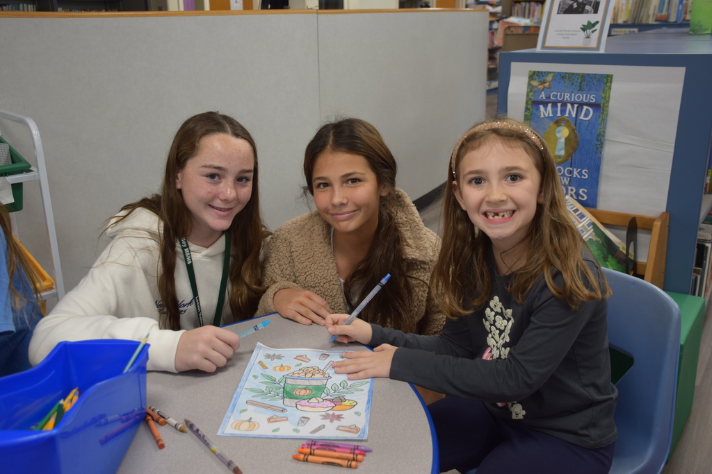 Middle school cheerleaders color with a BP student.